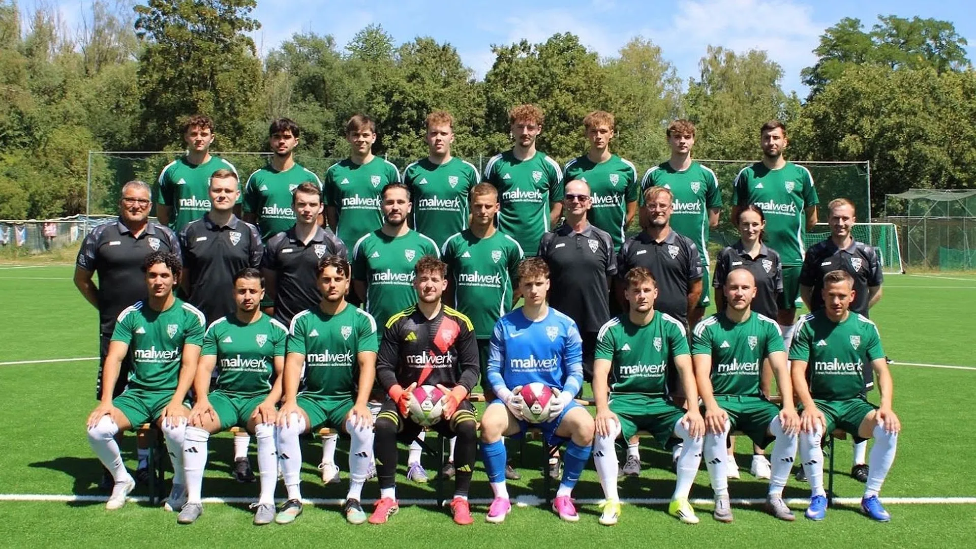 Mannschaftsfoto der 1. Herren in grünen Trikots auf dem Kunstrasen, Saison 2026/27
